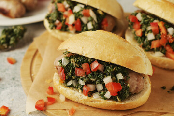 Choripan - bread with grilled sausages with chimichurri sauce, traditional Argentinian fast food dish