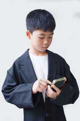 Little asian boy using smartphone on white background with copy space.