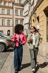 Fototapeta premium A woman is talking to a female friend who is walking next to her while they are holding ice cream