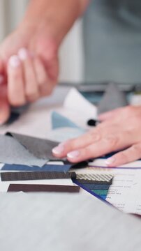 closeup female hands arranging fabric swatches, tactile exploration of color and texture on moodboard, designer comparing upholstery samples, neat manicure, calm focused studio atmosphere, sustainable