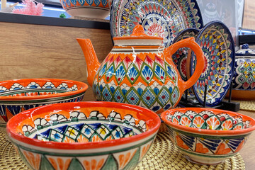A teapot with an oriental pattern on the shelf of a kitchenware store.