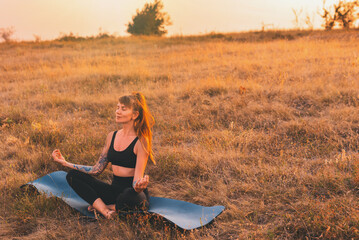 Woman in Lotus Pose on Yoga Mat at Sunset