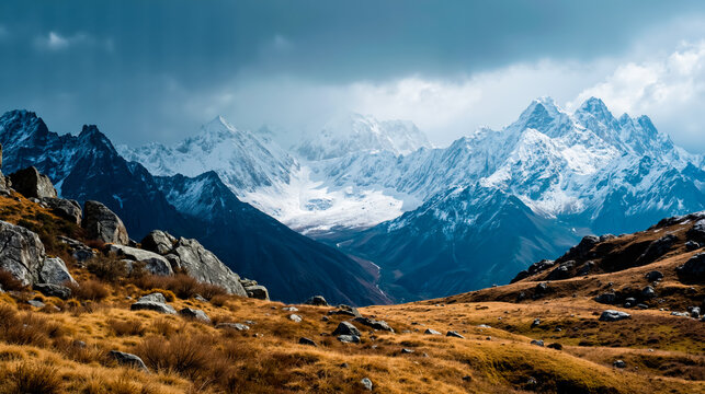 A picturesque landscape featuring a rocky foreground a valley and majestic snow-capped mountains under a cloudy sky - Powered by Adobe