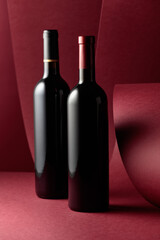 Bottles of red wine on a red background.