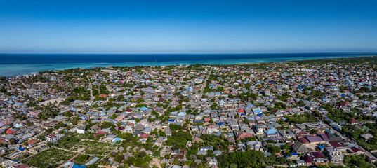 aerial view of Landscape of the northeast part of Nungwi,  a village  located in the far northern end of island of Zanzibar, with buildings, houses, infrastructure and turquoiseOcean in the background