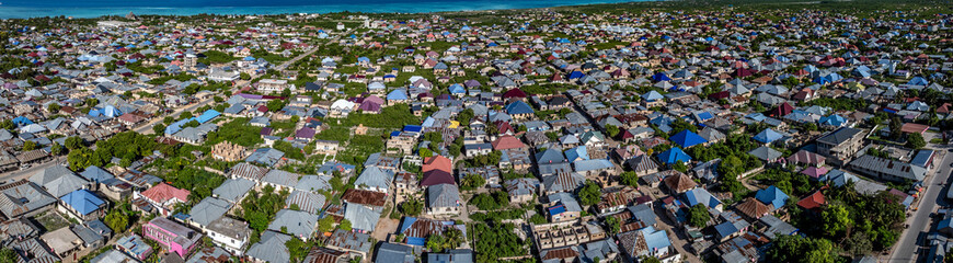 aerial view of Landscape from Nungwi Rd - to the east across Nungwi, a large village located in the far northern end of island of Zanzibar, with buildings, houses, infrastructure 