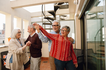 Obraz premium A man from behind has his hand on the shoulder and is holding the hand of a woman in front of him while they dance with two friends next to them and they are smiling and talking