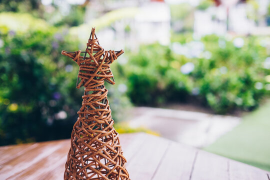 Closeup of handcrafted woven Christmas tree made from strong rattan material. Selective focus. Copy space.
