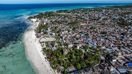 aerial landscape view along Nungwi beach - with white sand beach and turquoise water - a popular tourist destination, located in northwest part of Nungwi in the far northern end of island of Zanzibar