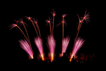 Colorful fireworks display exploding in dark night sky, festive celebration background with copy space.