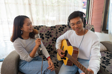 The couple is practicing playing a musical instrument.