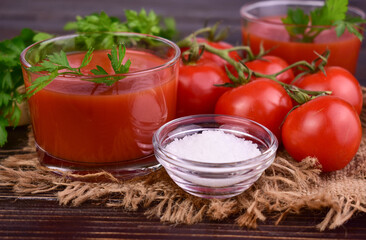 Fresh tomato juice on a dark wooden background. Close-up.
