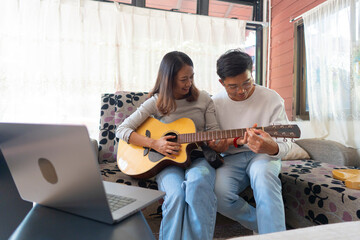 The couple is practicing playing a musical instrument.