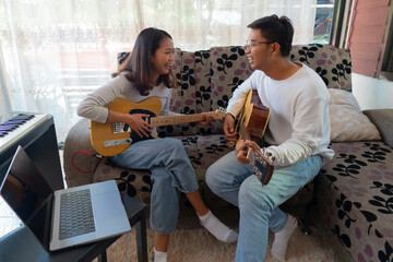 The couple is practicing playing a musical instrument.