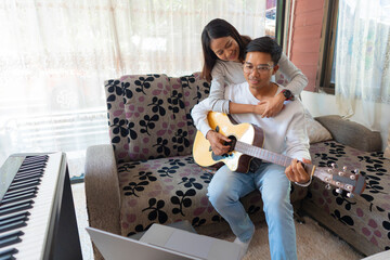 The couple is practicing playing a musical instrument.