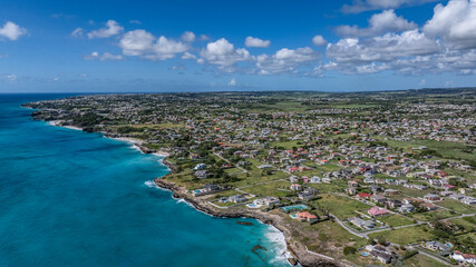 aerial landscape view across green Barbados Island in Saint Philip, a parish of Barbados at the easternmost end of the island with buildings, houses, cliffy coastline and turquoise water