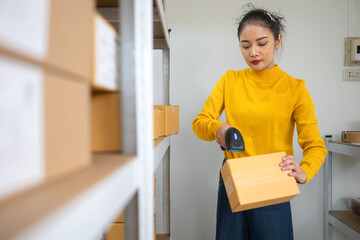 Female warehouse staff scanning barcode on cardboard box