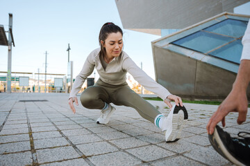Woman smiling while sitting and reaching for her feet