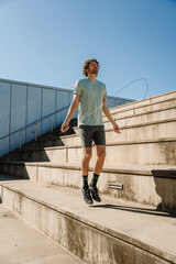 Man looking ahead and jumping rope on bleachers