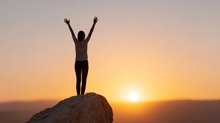 Triumphant woman celebrates reaching summit at sunset