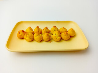 Mini choux with blueberry filling on a square plate. Isolated on white background. Delicious Snack.