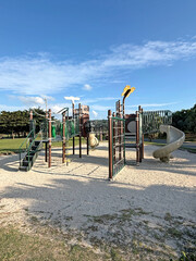 Modern playground equipment with slides and climbing structures on a sunny day