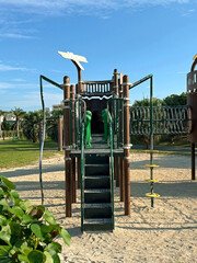 Modern playground structure with stairs and climbing elements on a sunny day