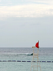 Red flag on lifeguard tower signals dangerous ocean conditions and swimming advisory