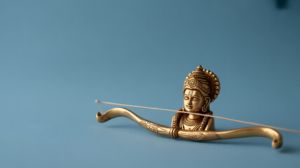 Golden figurine of a deity holding a bow and arrow against a blue background