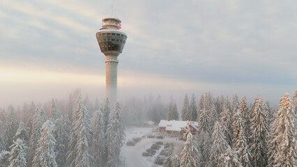 Scenic winter view of Puijo tower and cabin and surrounding snowy forest in Kuopio, Finland
