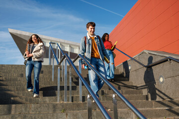 Diverse students descending campus stairs with books, reflecting education and youth