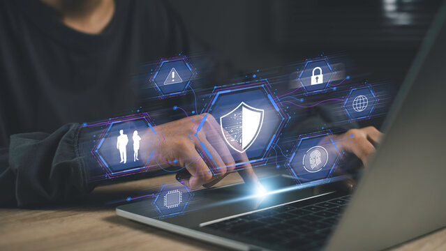 Cybersecurity and digital protection concept with password and firewall icons. Hands operating laptop with shield, lock, and secure information interface.