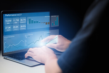 The man is using a laptop to analyze and track sales growth, comparing year-on-year sales. business dashboard interface with analytics widgets including charts, graphs, and statistics.
