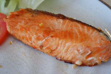 Grilled salmon fish fillet healthy food meal for dinner. Delicious closeup of cooked pink seafood protein on plate, an appetizing and tasty gourmet cuisine