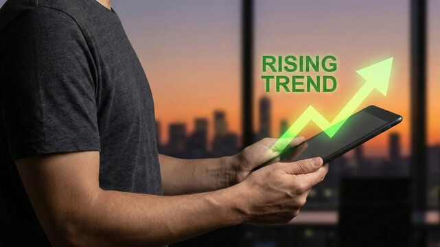 Rising trend upward arrow over tablet held by person at sunset city skyline, digital growth and business success visualization - Powered by Adobe