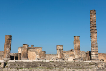 Columns in ancient Roman city temple ruins with blue sky