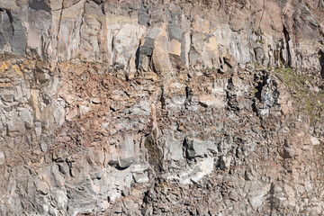 Closeup detail of hard rock wall on side of mountain