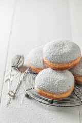 Sweet donuts with powdered sugar on cooling grate
