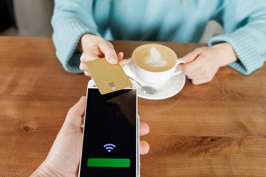 Mobile POS contactless card payment at cafe table using smartphone terminal