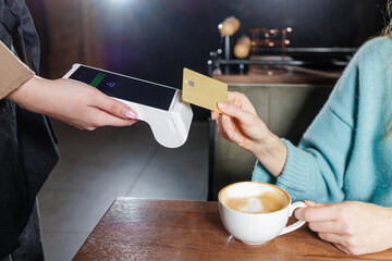 Tableside NFC tap to pay card transaction with portable POS terminal in cafe