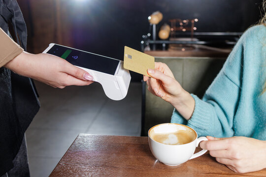 Tableside NFC tap to pay card transaction with portable POS terminal in cafe