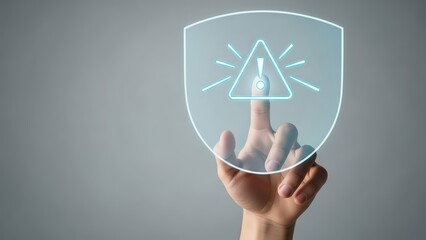 A luminous, digitally-rendered shield with a glowing warning symbol at its center is being gently touched by a human finger, suggesting activation or interaction with a cybersecurity system, presented
