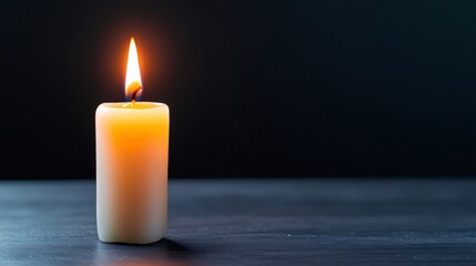 Single burning candle illuminating dark room, providing light and warmth