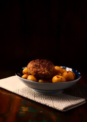Fried meatballs with potatoes on a rustic background. Selective and soft focus.