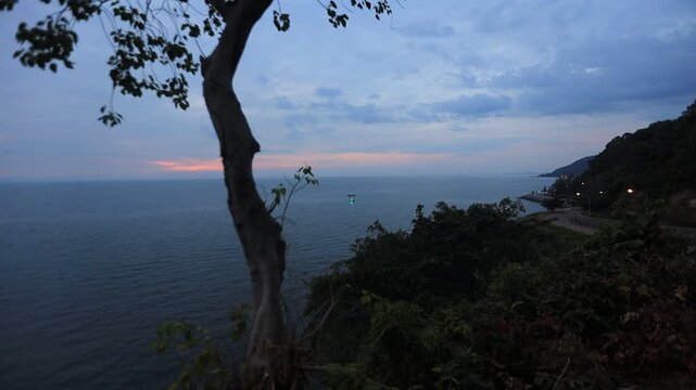 The video background depicts the waterfront, with twilight sky illuminating the riverside community and the lights from houses, reflecting the rural lifestyle of Chanthaburi, Thailand.