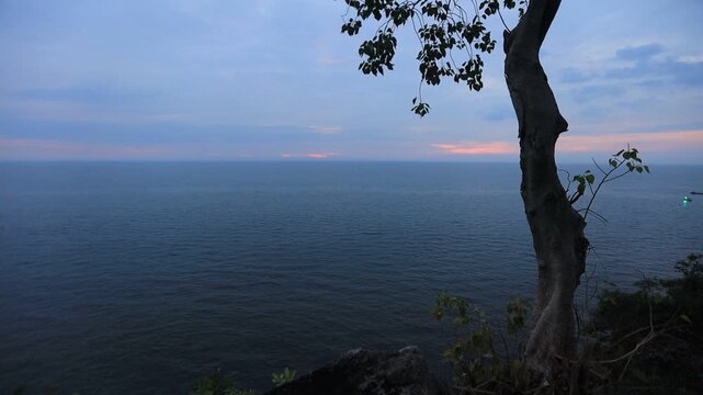 The video background depicts the waterfront, with twilight sky illuminating the riverside community and the lights from houses, reflecting the rural lifestyle of Chanthaburi, Thailand.
