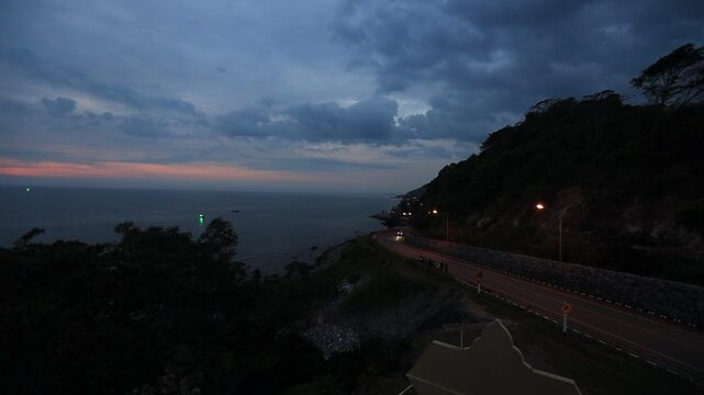 The video background depicts the waterfront, with twilight sky illuminating the riverside community and the lights from houses, reflecting the rural lifestyle of Chanthaburi, Thailand.