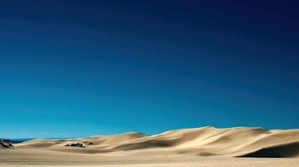 Wide View of Desert Sand Dunes with Expansive Blue Sky