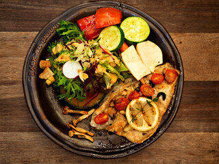 Grilled fish steak with mixed vegetable salad.