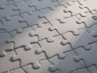 Interconnected textured white puzzle pieces forming a unified background surface